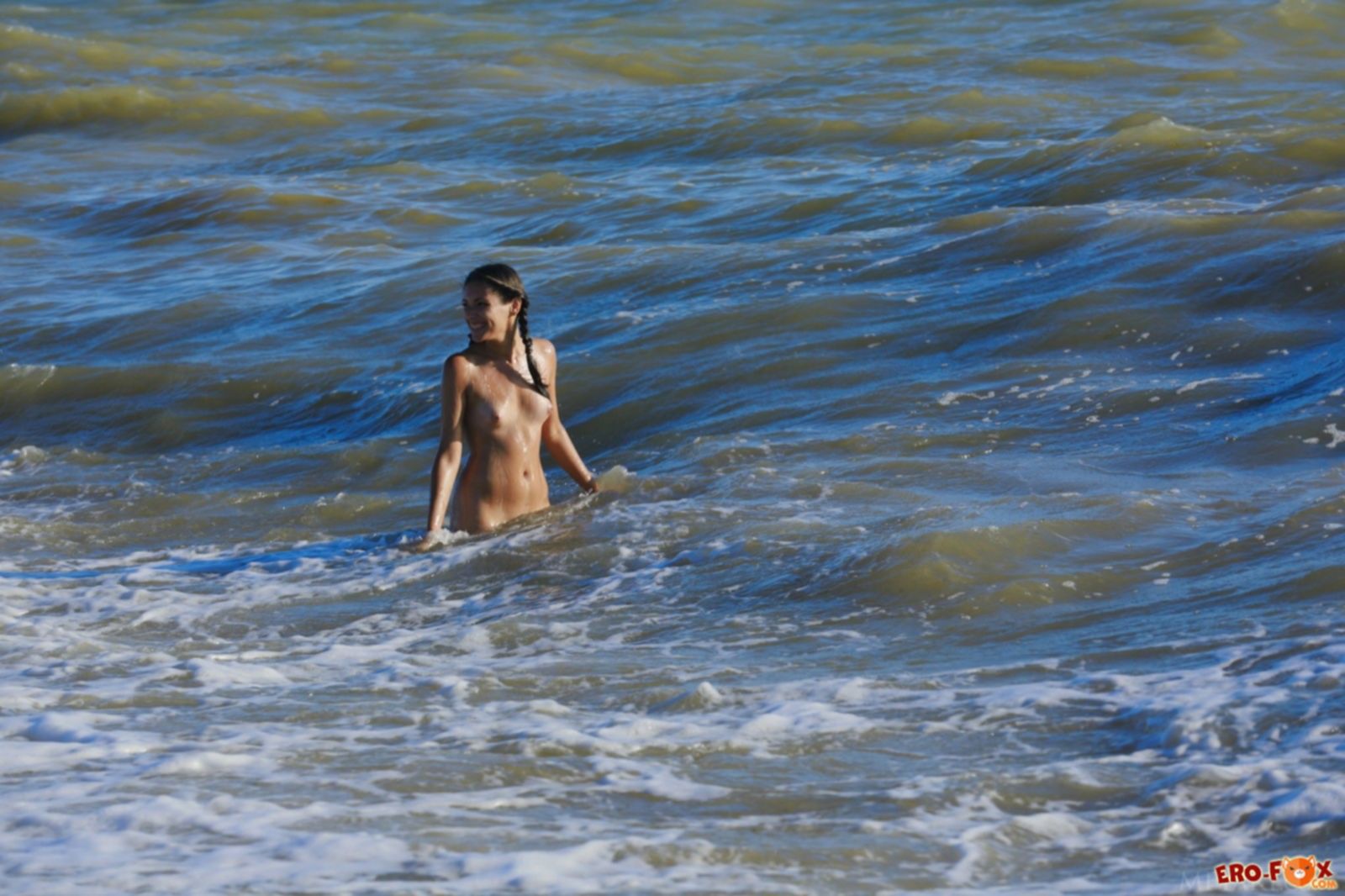 Милая модель сняв купальник позирует на пляже - фото